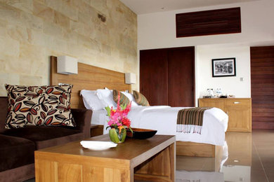 Ejemplo de dormitorio tropical extra grande con suelo de baldosas de cerámica y suelo marrón