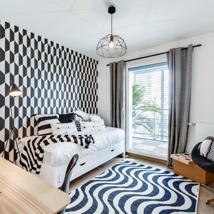 Inspiration pour une chambre d'amis design avec un mur blanc et un sol en bois clair.