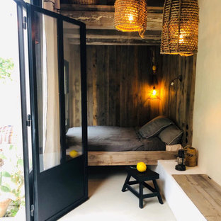 Modelo de habitación de invitados costera, pequeña, con paredes beige y suelo de cemento