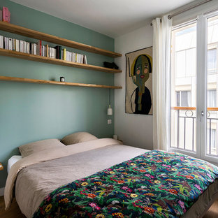 Cette image montre une chambre parentale design de taille moyenne avec un mur vert, un sol en bois brun, aucune cheminée et un sol marron.