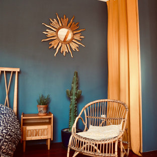 Cette photo montre une chambre parentale rétro avec un mur bleu, un sol en bois foncé et un sol marron.