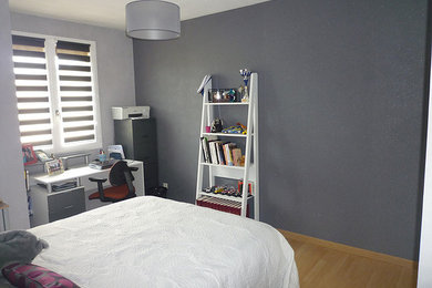 Inspiration pour une chambre d'amis design de taille moyenne avec un mur gris, sol en stratifié et un sol beige.