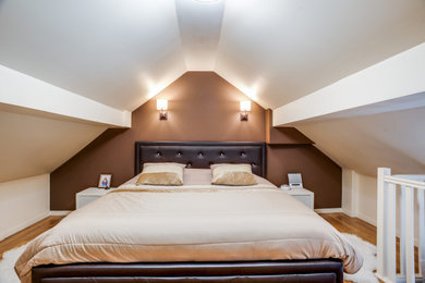 Exemple d'une chambre mansardée ou avec mezzanine moderne de taille moyenne avec un mur marron, sol en stratifié, un sol marron et aucune cheminée.