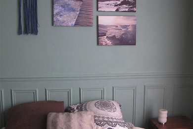 Imagen de dormitorio principal nórdico de tamaño medio con paredes verdes, suelo de madera clara y chimenea de esquina