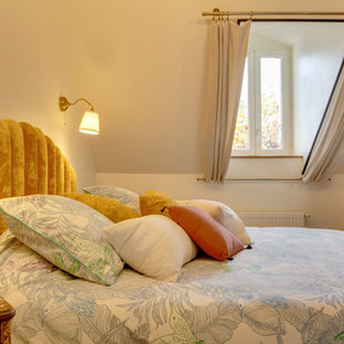 Foto de dormitorio principal, minimalista, pequeño, con parades naranjas, suelo laminado y suelo marrón