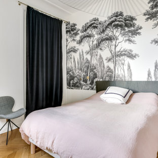 Exemple d'une chambre parentale tendance de taille moyenne avec un mur blanc, aucune cheminée, un sol marron et un sol en bois brun.