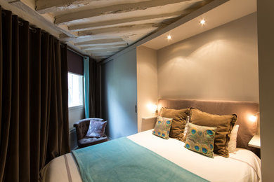 Modelo de dormitorio escandinavo con paredes beige y suelo de madera clara