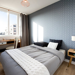Exemple d'une chambre parentale scandinave de taille moyenne avec un sol en bois brun, aucune cheminée et un mur bleu.