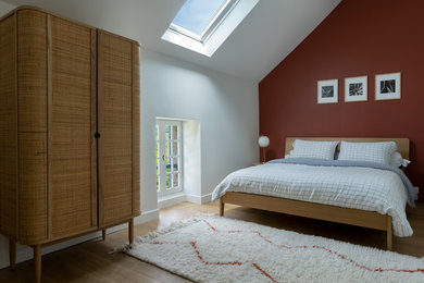 Cette image montre une chambre mansardée ou avec mezzanine bohème de taille moyenne avec un mur blanc, parquet clair et un sol beige.
