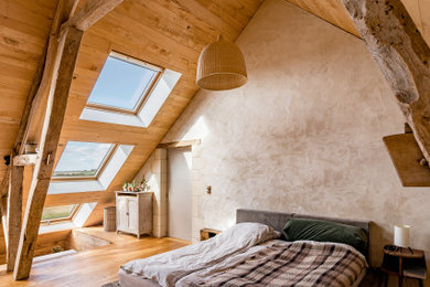 Modelo de dormitorio principal campestre de tamaño medio sin chimenea con paredes beige, suelo de madera en tonos medios, suelo beige y madera