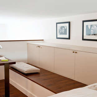Idées déco pour une chambre mansardée ou avec mezzanine contemporaine avec un mur blanc, un sol en bois foncé et un sol marron.