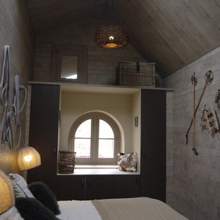 Exemple d'une petit chambre mansardée ou avec mezzanine tendance avec un mur gris.