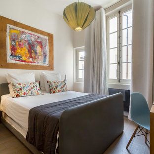 Réalisation d'une chambre design avec un mur blanc et un sol en bois clair.