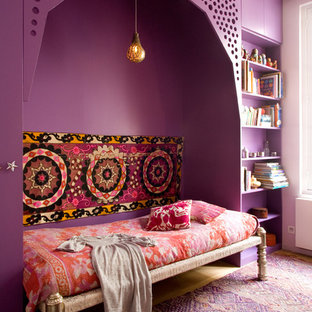 Réalisation d'une chambre parentale bohème avec un mur violet, un sol en bois clair et aucune cheminée.