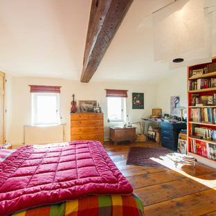 Cette photo montre une chambre parentale nature avec un mur beige et un sol en bois foncé.