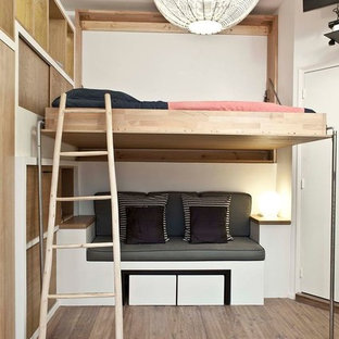 Esempio di una piccola camera da letto stile loft contemporanea con pareti bianche, pavimento in legno massello medio e nessun camino