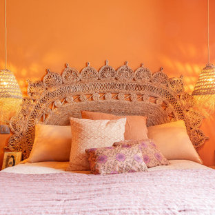 Diseño de dormitorio principal, actual, de tamaño medio, sin chimenea, con parades naranjas, suelo de madera clara y suelo beige