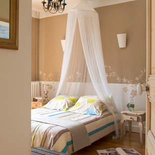 Aménagement d'une chambre parentale classique de taille moyenne avec un mur multicolore, un sol en bois brun et aucune cheminée.