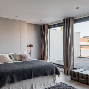 Idées déco pour une chambre contemporaine avec un mur gris, un sol en bois clair et un sol beige.