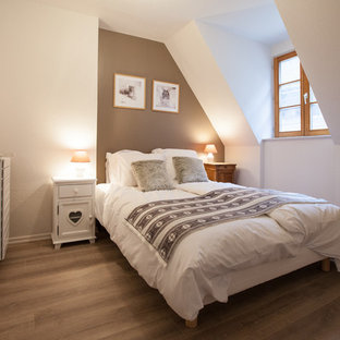 Foto de dormitorio principal, campestre, pequeño, sin chimenea, con paredes marrones, suelo laminado y suelo marrón