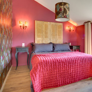 Cette photo montre une chambre méditerranéenne avec un mur rouge, un sol en bois brun et un sol marron.