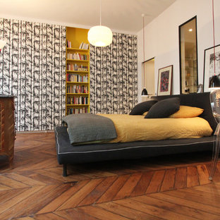 Exemple d'une grand chambre parentale tendance avec un mur multicolore et un sol en bois brun.