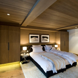 Diseño de dormitorio rural con paredes marrones y suelo de madera clara