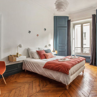 Inspiration pour une chambre traditionnelle avec un mur blanc, un sol en bois brun et aucune cheminée.