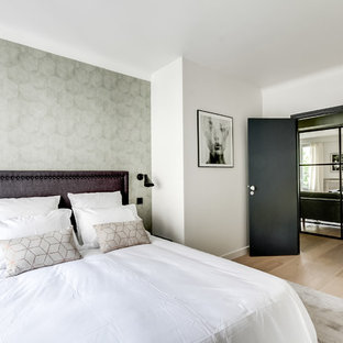 Réalisation d'une chambre d'amis design avec un mur blanc, un sol en bois clair et un sol beige.