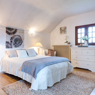 Inspiration pour une grand chambre parentale traditionnelle avec un mur blanc et un sol en bois clair.