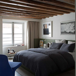 Modelo de dormitorio contemporáneo con paredes blancas, suelo de cemento y suelo gris