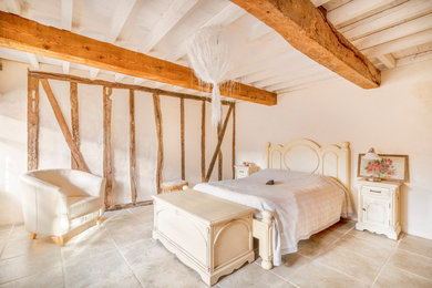 Ejemplo de dormitorio principal mediterráneo sin chimenea con paredes beige y suelo beige