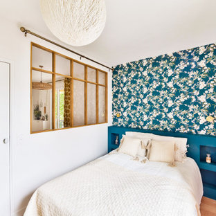 Inspiration pour une chambre nordique de taille moyenne avec un mur bleu, un sol en bois clair, aucune cheminée et du papier peint.