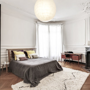 Aménagement d'une chambre classique avec un mur blanc, un sol en bois brun et une cheminée d'angle.