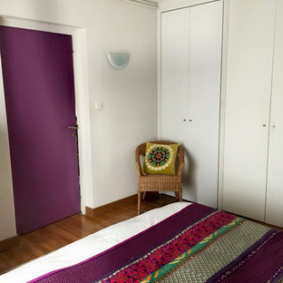 Imagen de dormitorio principal, tropical, de tamaño medio, con paredes púrpuras, suelo de madera oscura y suelo marrón