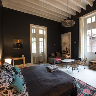 Cette image montre une grand chambre parentale bohème avec un mur noir et aucune cheminée.