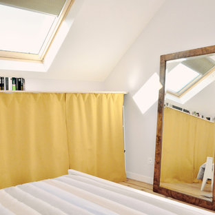 Modelo de dormitorio principal, moderno, grande, sin chimenea, con paredes púrpuras y suelo de madera clara