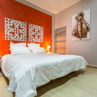 Réalisation d'une chambre parentale bohème de taille moyenne avec un sol en bois clair et un mur orange.