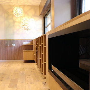Idee per un'ampia camera degli ospiti contemporanea con pareti viola, parquet chiaro, camino sospeso, cornice del camino in legno e pavimento marrone
