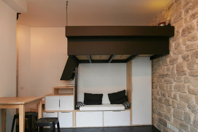 Idée de décoration pour une petite chambre mansardée ou avec mezzanine urbaine avec un mur blanc et sol en béton ciré.