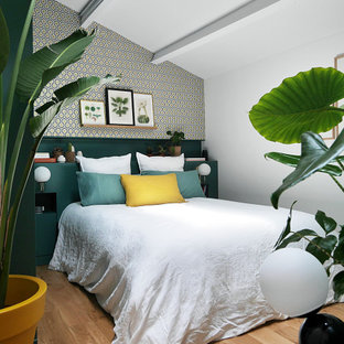 Mittelgroßes Modernes Gästezimmer mit bunten Wänden, braunem Holzboden, braunem Boden, freigelegten Dachbalken, gewölbter Decke und Tapetenwänden in Paris