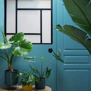 Imagen de habitación de invitados minimalista, de tamaño medio, con paredes azules, suelo de madera clara y suelo beige