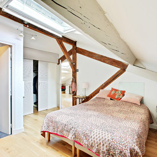 Inspiration pour une chambre parentale ethnique de taille moyenne avec un mur blanc, un sol en bois brun et un sol marron.