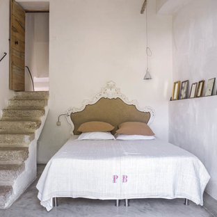 Exemple d'une chambre d'amis méditerranéenne de taille moyenne avec un mur blanc, béton au sol et aucune cheminée.