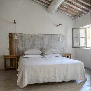 Idée de décoration pour une chambre d'amis champêtre de taille moyenne avec un mur blanc, béton au sol et aucune cheminée.