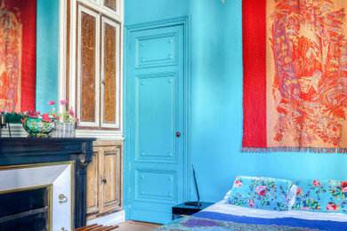 Ejemplo de habitación de invitados clásica renovada de tamaño medio con paredes azules, suelo de madera oscura y todas las chimeneas
