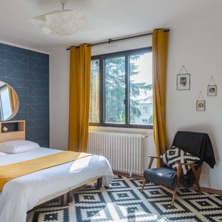 Cette image montre une grand chambre parentale design avec un mur bleu, un sol en bois brun et un sol marron.