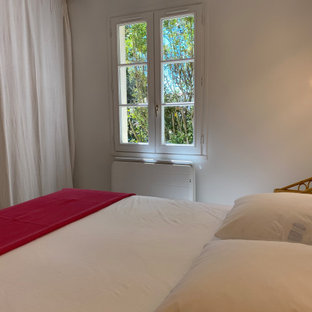 Diseño de dormitorio marinero, pequeño, con paredes blancas, suelo de piedra caliza y suelo beige