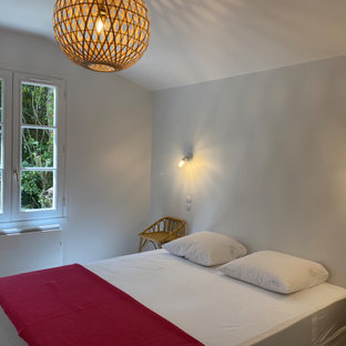 Foto de dormitorio marinero, pequeño, con paredes blancas, suelo de piedra caliza y suelo beige
