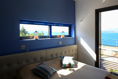Cette image montre une petite chambre parentale design avec un mur bleu.